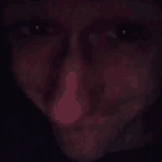 a close up of a person 's face with a dark background