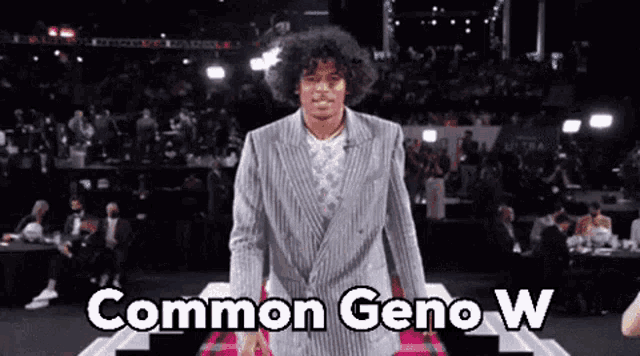 a man in a suit is standing in front of a crowd with the words common geno w written on the bottom