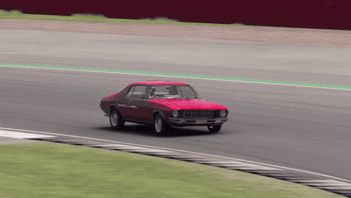 a red car is driving on a race track and has a license plate that says ' jcw ' on it