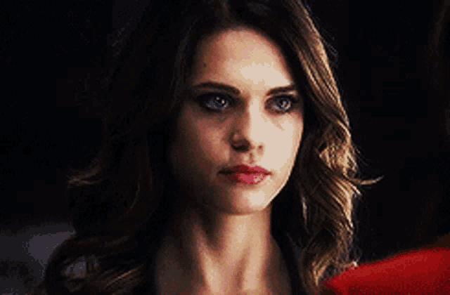 a close up of a woman 's face with a red shirt on .