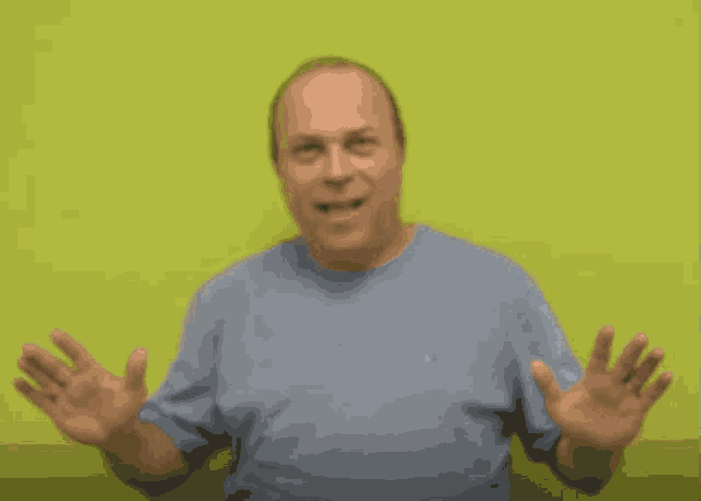 a man in a blue shirt waves his hand