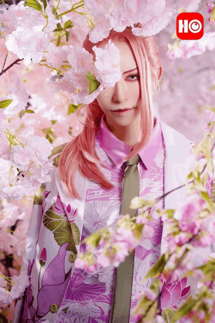 a woman with pink hair is surrounded by pink flowers and a red hc logo