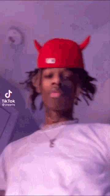 a man wearing a red hat with devil horns on it