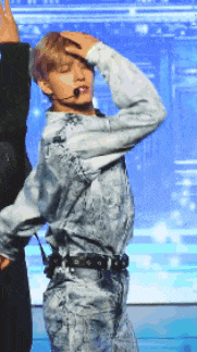 a man in a tie dye shirt is dancing on stage