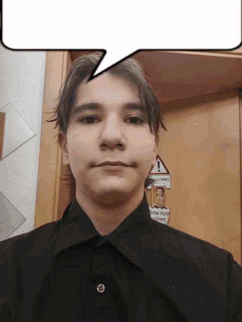 a young man stands in front of a door with a sign on it that says achtung