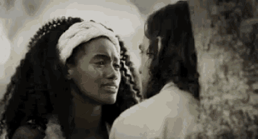 a man and a woman are standing next to each other and looking at each other . the woman is crying .