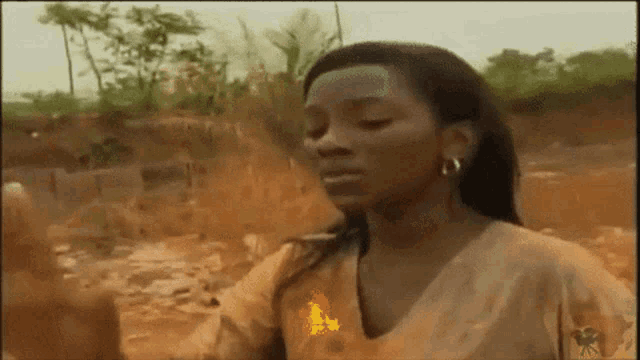 a woman is standing in a field with a fire coming out of her hand