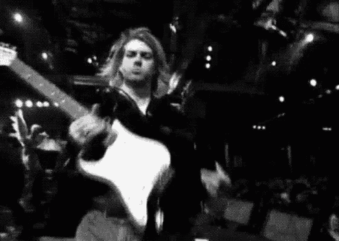 a black and white photo of a man playing an electric guitar