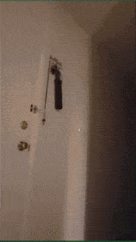 a fire extinguisher is hanging from a hook on a white wall