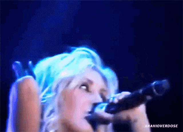 a close up of a woman singing into a microphone with the words amahioverdose written below her
