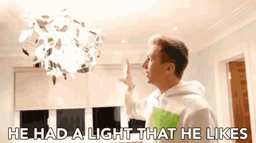 a man standing in front of a chandelier with the words he had a light that he likes below him