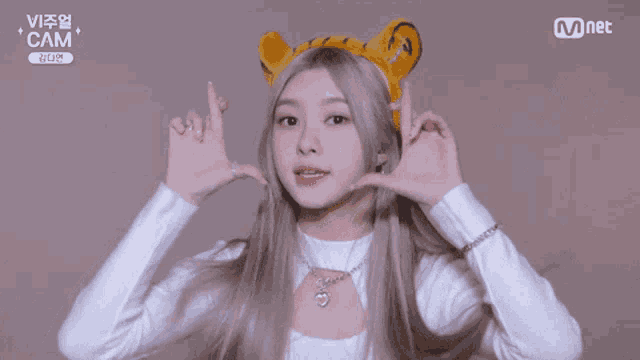 a girl wearing a headband with tiger ears and a mnet logo on the bottom