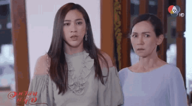 two women are standing next to each other in a room .