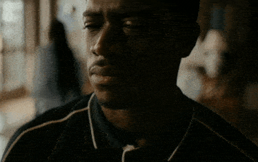 a close up of a man 's face with a black shirt on