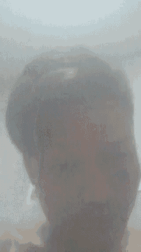 a close up of a person 's face behind a glass wall .