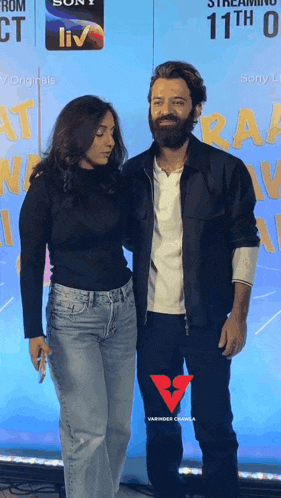 a man and a woman standing next to each other in front of a sign that says sony liv