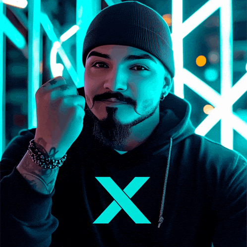 a man with a beard wearing a black hoodie with a blue x on it