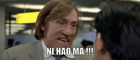a man in a suit and tie holds a gun and says ni hao ma !!!