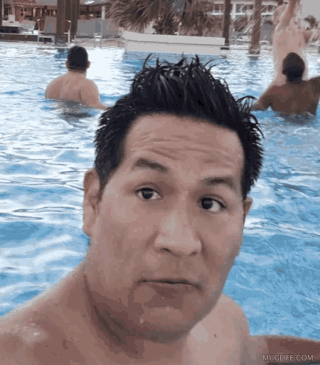 a man taking a picture of himself in a swimming pool with the website mlglife.com in the lower right corner