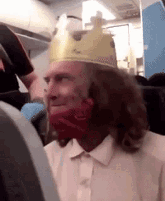 a man wearing a crown and a red bandana on his face