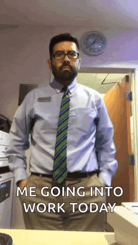 a man in a shirt and tie is standing in front of a clock and says me going into work today .