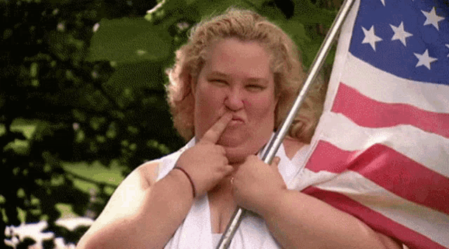 a woman holding an american flag and making a funny face