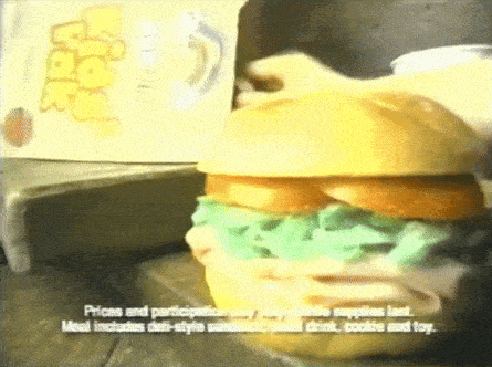 a close up of a hamburger with a box in the background that says ' mcdonald 's ' on it