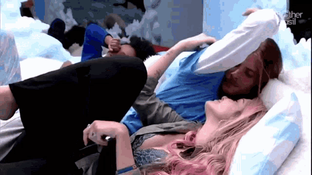 a woman with pink hair is laying on a man 's lap in a room that says ' another brasil ' on it