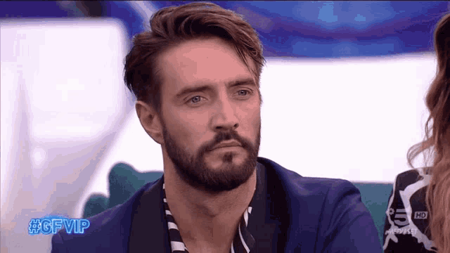 a man with a beard is sitting in front of a tv screen that says #gfvip