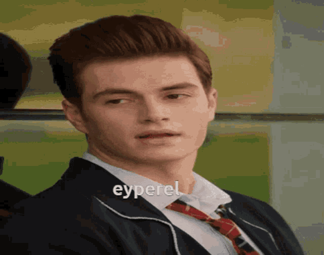 a young man wearing a suit and tie has the word eyperel on his shirt