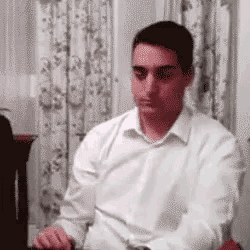 a man in a white shirt is sitting at a table