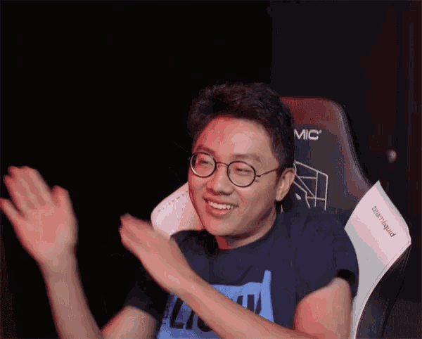a man wearing glasses is sitting in a chair that says mic on it