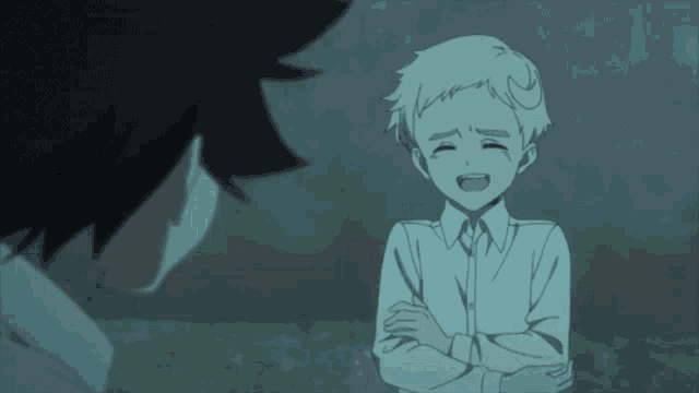 a boy with his arms crossed is talking to another boy with his eyes closed