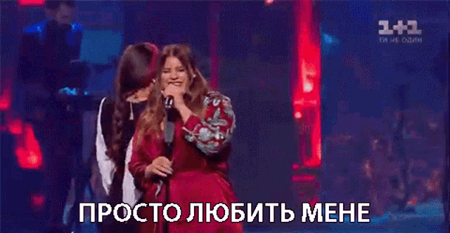 a woman in a red dress singing into a microphone with a caption that says просто любить мне