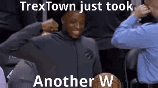 a man is sitting in the stands with a basketball and a caption that says trextown just took another w.