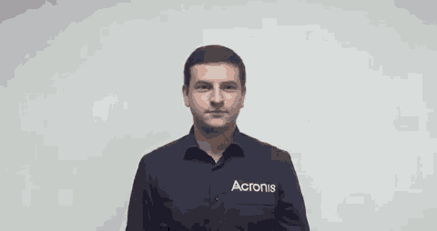 a man wearing a black shirt with acronis written on it is smiling .