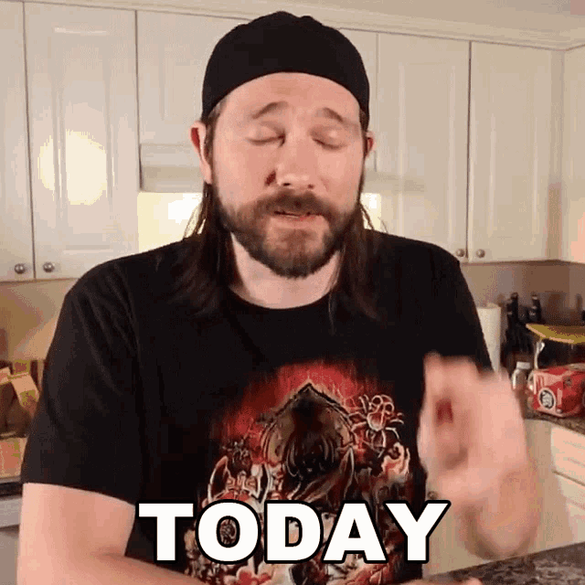 a man with long hair and a beard wears a black shirt that says today