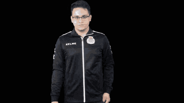 a man wearing a black jacket that says kelme
