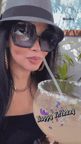 a woman wearing sunglasses and a hat is drinking from a margarita with the words happy birthday written on the glass