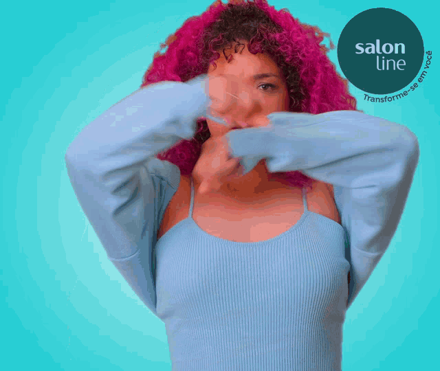 a woman with pink hair is standing with her arms crossed in front of a logo for salon line