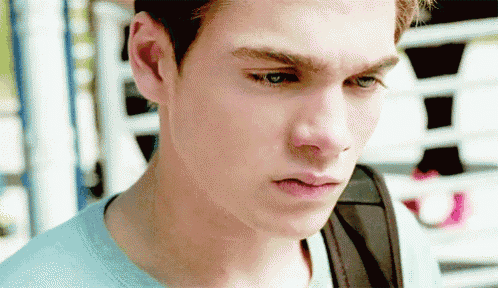 a close up of a young man 's face with a backpack on his shoulder