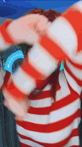 a person is wearing a red and white striped shirt and dancing .