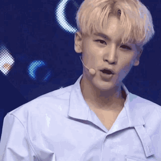 a young man wearing a blue shirt and a microphone .