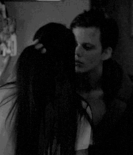 a black and white photo of a man holding a woman 's hair .