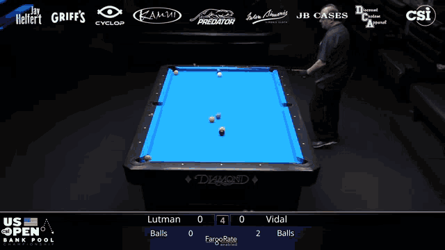 a pool table with a blue cloth and a man playing pool