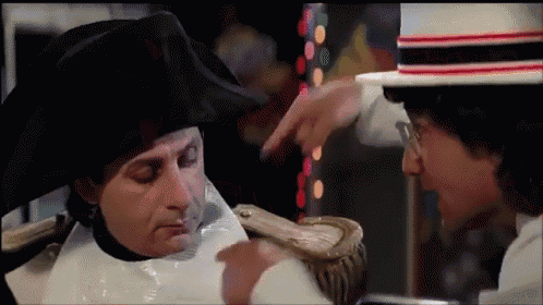 a man in a black hat is pointing at a man in a white hat
