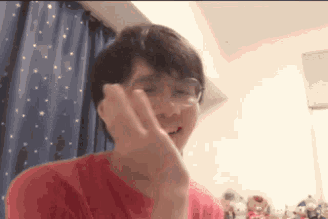 a man wearing glasses and a red shirt is smiling