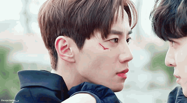 a close up of a man 's face with a red spot on his cheek