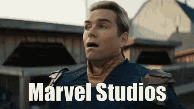 a man with a surprised look on his face is standing in front of a building with the words marvel studios on the bottom