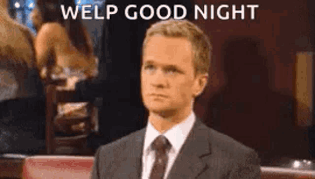 a man in a suit and tie is sitting at a table in a restaurant and says welp good night .